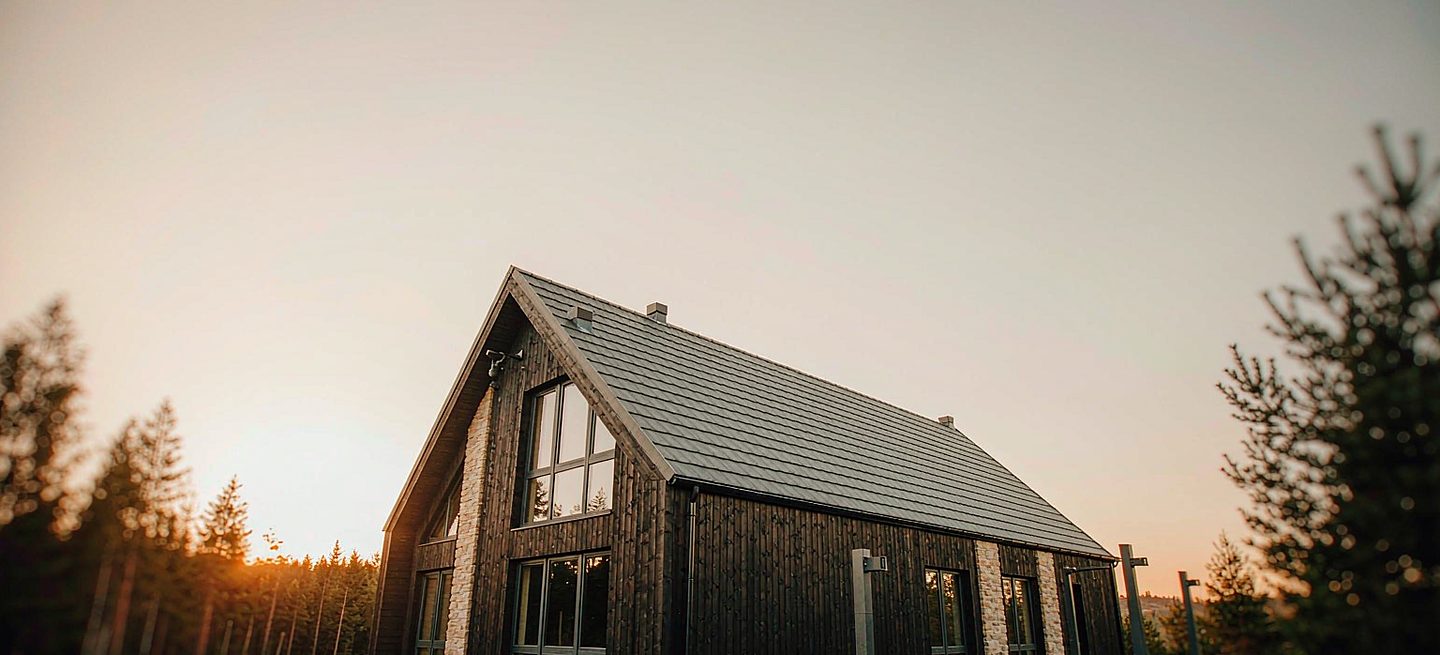 A timber cabin at golden hour with mount points on the roof ridge, under the eave and on a freestanding post in the yard